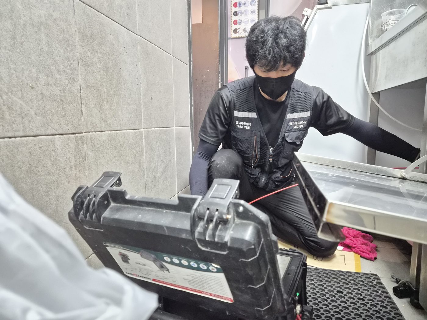 카메라 화면을 보며 배관 상태를 확인하는 작업자