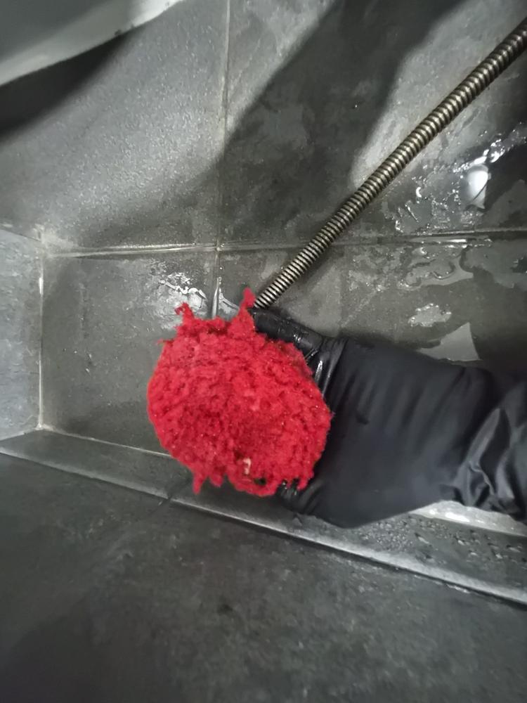 바닥 배수 쪽에서 와이어 장비로 작업하는 모습